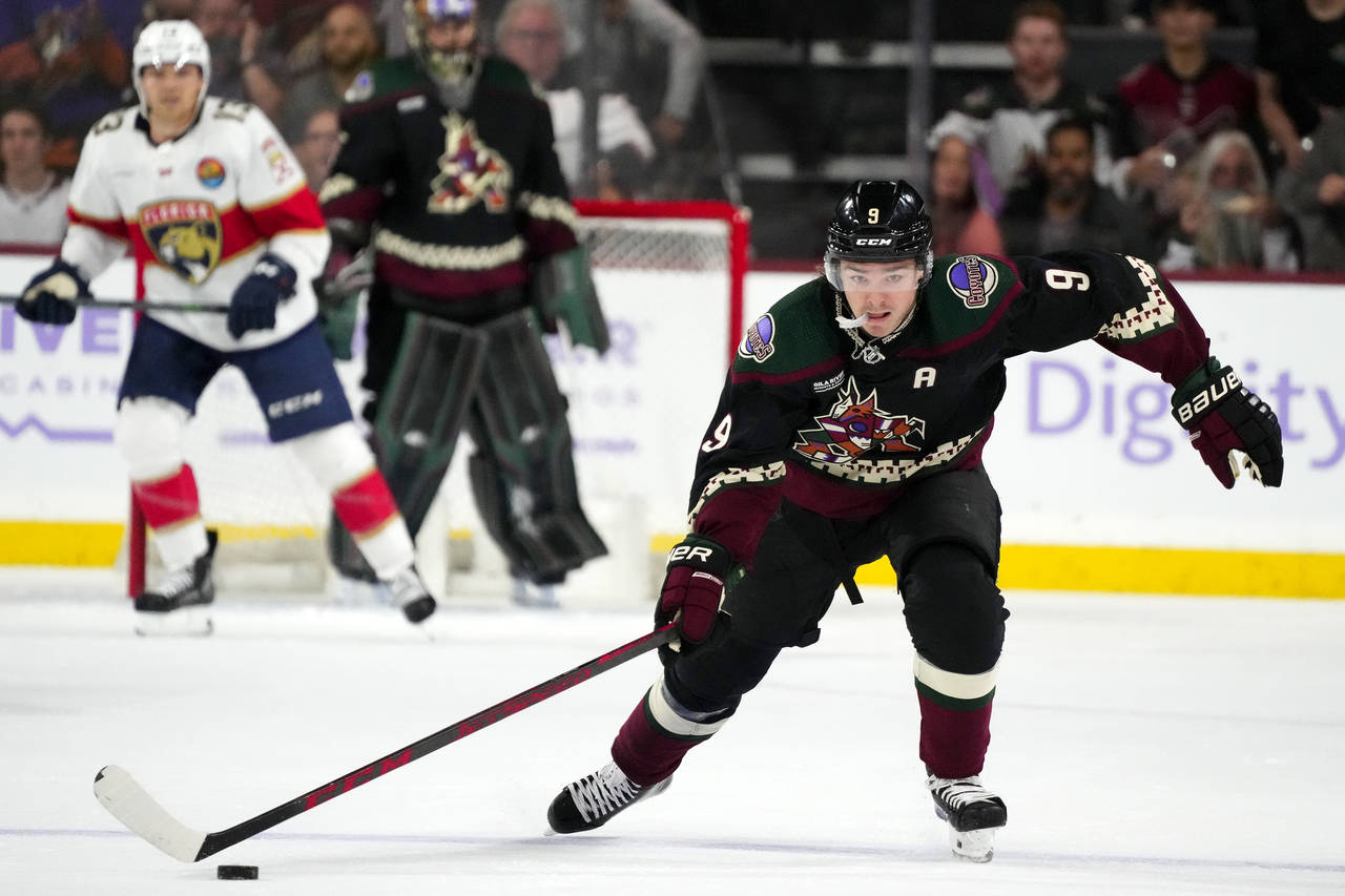 Arizona Coyotes right wing Clayton Keller skates with the puck before scoring an empty-net goal aga...