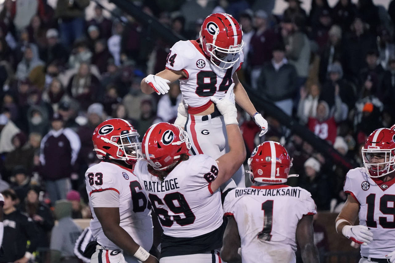 Georgia wide receiver Ladd McConkey (84) gets a lift from offensive lineman Tate Ratledge (69) afte...