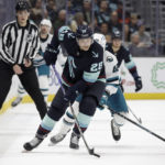
              Seattle Kraken defenseman Carson Soucy slates with the puck as San Jose Sharks left wing Jonah Gadjovich (42) gives chase during the first period of an NHL hockey game, Wednesday, Nov. 23, 2022, in Seattle. (AP Photo/John Froschauer)
            