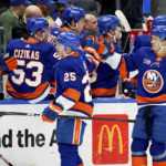 
              New York Islanders defenseman Sebastian Aho (25) and center Mathew Barzal (13) high-five the bench after Barzal's goal during the first period of an NHL hockey game against the Calgary Flames, Monday, Nov. 7, 2022, in Elmont, N.Y. (AP Photo/Julia Nikhinson)
            