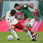 
              Mexico's Alexis Vega, right, and Poland's Grzegorz Krychowiak, battle for the ball during the World Cup group C soccer match between Mexico and Poland, at the Stadium 974 in Doha, Qatar, Tuesday, Nov. 22, 2022. (AP Photo/Aijaz Rahi)
            