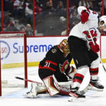 
              The puck enters the net behind Ottawa Senators goaltender Anton Forsberg (31) on a shot from New Jersey Devils left wing Erik Haula (56), not shown, as New Jersey Devils right wing Nathan Bastian (14) plays at the top of the crease, during first period of an NHL hockey game in Ottawa, on Saturday, Nov. 19, 2022.  (Justin Tang /The Canadian Press via AP)
            