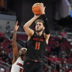 
              Maryland forward Noah Batchelor (11) shoots over Louisville guard El Ellis during the second half of an NCAA college basketball game in Louisville, Ky., Tuesday, Nov. 29, 2022. Maryland won 79-54. (AP Photo/Timothy D. Easley)
            