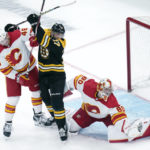
              Boston Bruins left wing Nick Foligno (17) tangles with Calgary Flames defenseman Dennis Gilbert, left, as Flames goaltender Dan Vladar (80) makes a save during the first period of an NHL hockey game, Thursday, Nov. 10, 2022, in Boston. (AP Photo/Charles Krupa)
            