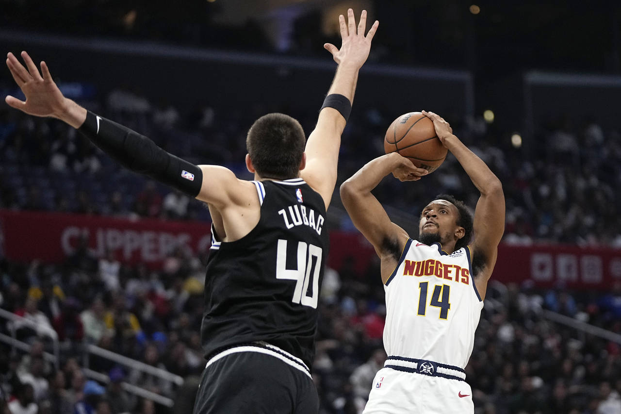 Denver Nuggets guard Ish Smith, right, shoots as Los Angeles Clippers center Ivica Zubac defends du...