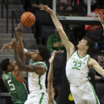 
              Florida A&M forward Jaylen Bates (5) is fouled by Oregon guard Rivaldo Soares (11) as center Nate Bittle (32) comes in on the play during the first half of an NCAA college basketball game Monday, Nov. 7, 2022, in Eugene, Ore. (AP Photo/Andy Nelson)
            