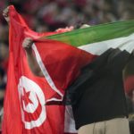 
              Fans hold the flag of Palestine and Tunisia during the World Cup group D soccer match between Denmark and Tunisia, at the Education City Stadium in Al Rayyan, Qatar, Tuesday, Nov. 22, 2022. (AP Photo/Ariel Schalit)
            
