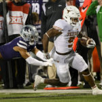
              Texas running back Bijan Robinson (5) escapes a tackle by Kansas State safety Kobe Savage (2) during the first half of an NCAA college football game Saturday, Nov. 5, 2022, in Manhattan, Kan. (AP Photo/Reed Hoffmann)
            