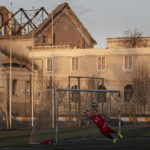 
              A goalkeeper tries to make a save during a soccer match in front of a war-damaged building in the stadium in the city of Irpin, Ukraine Saturday Nov. 13, 2022, which was badly damaged by the Russian army during their occupation. (AP Photo/Andrew Kravchenko)
            