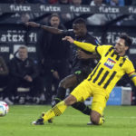 
              Monchengladbach's Marcus Thuram and Dortmund's Mats Hummels, right, battle for the ball during the Bundesliga soccer match between Borussia Monchengladbach and Borussia Dortmund at Borussia-Park, Monchengladbach, Germany, Friday Nov. 11, 2022. (Bernd Thissen/dpa via AP)
            