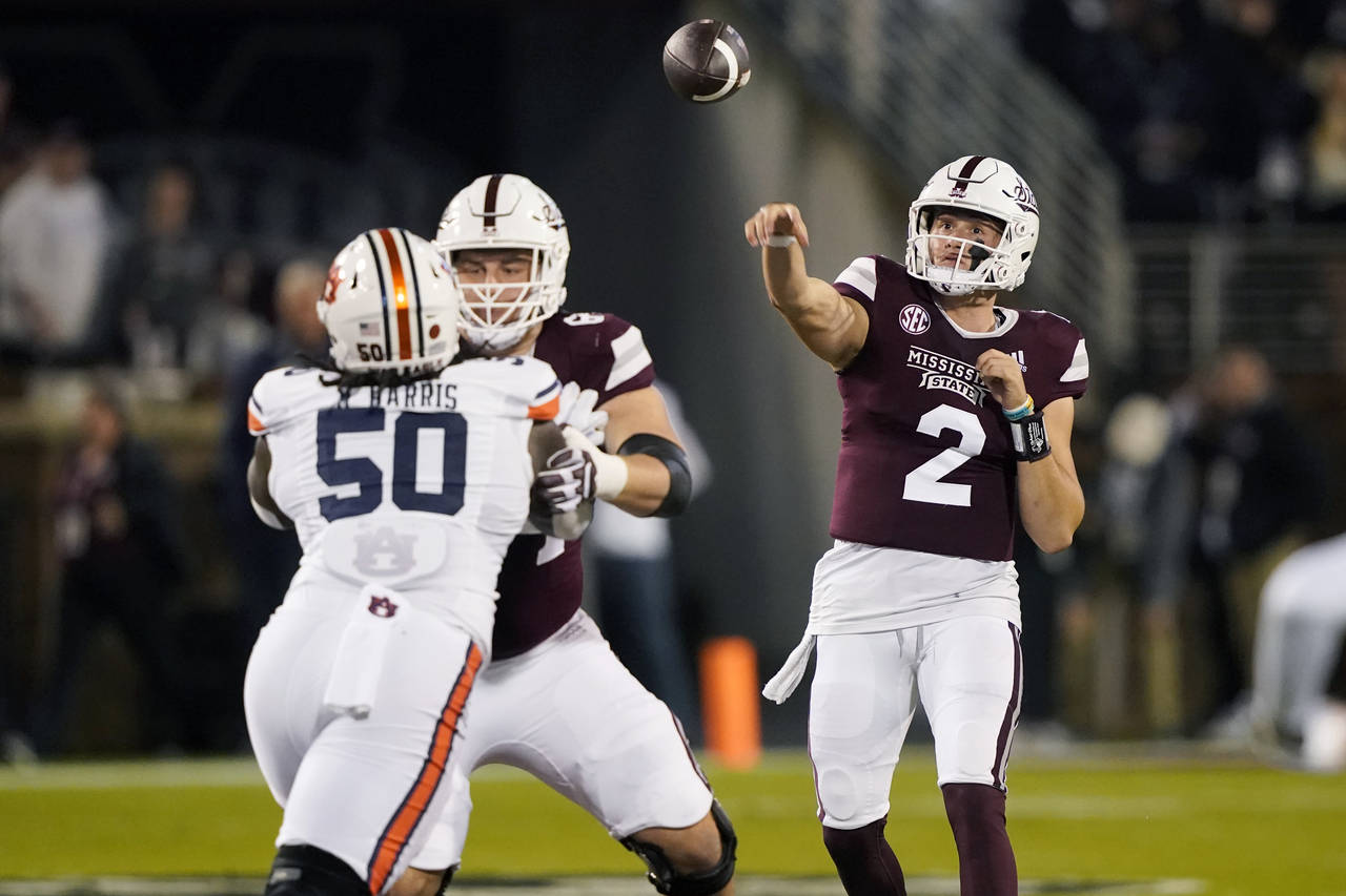 Mississippi State quarterback Will Rogers (2) throws a pass as Auburn defensive lineman Marcus Harr...