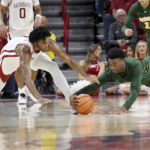
              Arkansas guard Ricky Council IV, left, and North Dakota State guard Tajavis Miller, right, dive after the ball during the first half of an NCAA college basketball game Monday, Nov. 7, 2022, in Fayetteville, Ark. (AP Photo/Michael Woods)
            