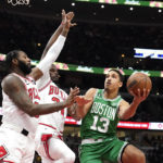 
              Boston Celtics' Malcolm Brogdon (13) drives to the basket as Chicago Bulls' Andre Drummond, left, and Javonte Green defend during the first half of an NBA basketball game Monday, Nov. 21, 2022, in Chicago. (AP Photo/Charles Rex Arbogast)
            