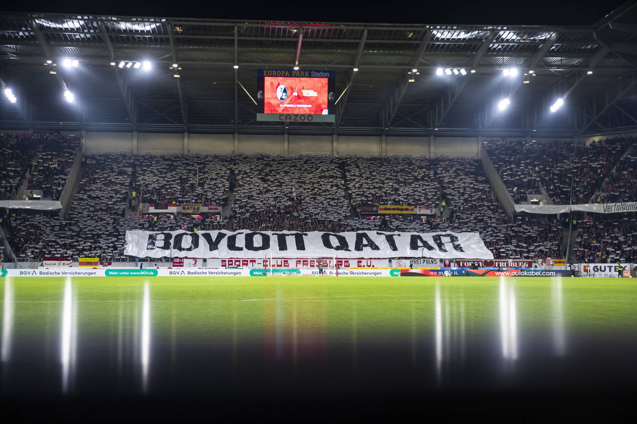 SC Freiburg fans display a banner with the inscription "Boycott Qatar" as a protest action against ...