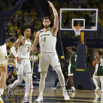 
              Michigan center Hunter Dickinson (1) reacts after making a 3-point basket as time expired in the first half of an NCAA college basketball game against Ohio, Sunday, Nov. 20, 2022, in Ann Arbor, Mich. (AP Photo/Jose Juarez)
            