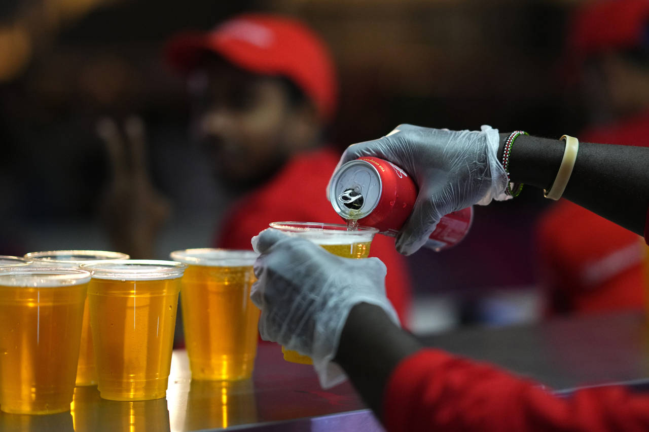 FILE - Staff member pours a beer at a fan zone ahead of the FIFA World Cup, in Doha, Qatar Saturday...