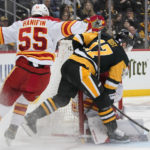 
              Pittsburgh Penguins' Bryan Rust (17) can't get a shot off in front of Calgary Flames goaltender Dan Vladar, rear, with Noah Hanifin (55) defending during the second period of an NHL hockey game in Pittsburgh, Wednesday, Nov. 23, 2022. (AP Photo/Gene J. Puskar)
            