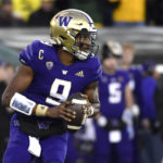 
              Washington quarterback Michael Penix Jr. (9) rolls away from Oregon defenders and looks for a receiver during the first half of an NCAA college football game Saturday, Nov. 12, 2022, in Eugene, Ore. (AP Photo/Andy Nelson)
            