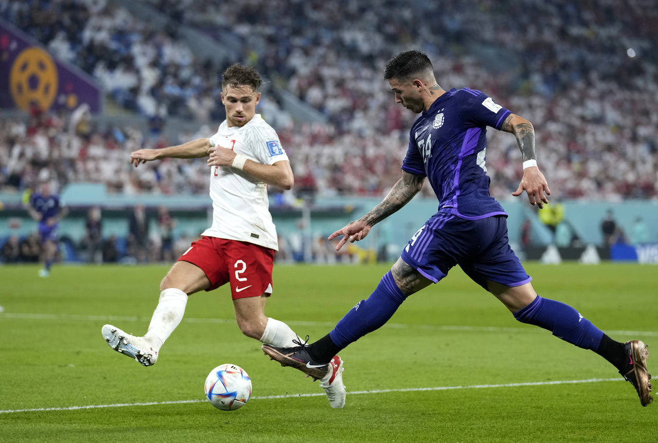 Argentina's Enzo Fernandez, right, kicks a the ball as Poland's Matty Cash defends during the World...