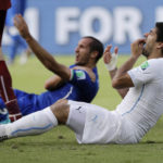 
              FILE - Uruguay's Luis Suarez holds his teeth after colliding with Italy's Giorgio Chiellini's shoulder during the group D World Cup soccer match between Italy and Uruguay at the Arena das Dunas in Natal, Brazil on June 24, 2014. (AP Photo/Ricardo Mazalan, File)
            