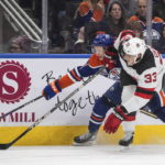 
              New Jersey Devils' Ryan Graves (33) and Edmonton Oilers' Ryan McLeod (71) vie for the puck during the second period of an NHL hockey game Thursday, Nov. 3, 2022, in Edmonton, Alberta. (Jason Franson/The Canadian Press via AP)
            