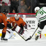 
              Dallas Stars left wing Jason Robertson (21) gets a shot off at Arizona Coyotes goaltender Connor Ingram (39) as Coyotes center Nick Bjugstad (17) defends during the first period of an NHL hockey game in Tempe, Ariz., Thursday, Nov. 3, 2022. (AP Photo/Ross D. Franklin)
            
