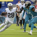 
              Las Vegas Raiders running back Josh Jacobs (28) tries to get past Jacksonville Jaguars safety Andre Cisco (5) in the first half of an NFL football game Sunday, Nov. 6, 2022, in Jacksonville, Fla. (AP Photo/Phelan M. Ebenhack)
            