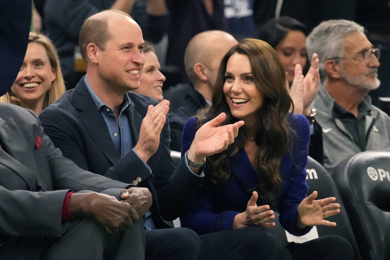 Britain's Prince William and Kate, Princess of Wales, right, laugh during the second half of an NBA...