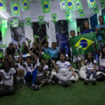 
              Students celebrate as they learn that Vinicius Jr. is on the list of players for the 2022 Soccer World Cup in Qatar, at the Paulo Freire municipal school where he studied, in Sao Goncalo, Rio de Janeiro state, Brazil, Monday, Nov. 7, 2022. Four years ago teenager Vinicius Jr. took his first medal from a professional soccer tournament home, a place where drug gangs and vigilantes fight for control and children dribble past garbage on the streets. Today, Vinicius is a key figure on Brazil’s World Cup team. (AP Photo/Bruna Prado)
            