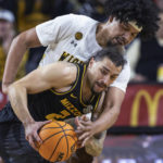 
              Wichita State's Isaiah Poor Bear Chandler, top, defends agianst Missouri's Tre Gomillion during the first half of an NCAA college basketball game Tuesday, Nov. 29, 2022, in Wichita, Kan. (Travis Heying/The Wichita Eagle via AP)
            