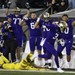 
              Washington wide receiver Taj Davis (3) eludes a tackle by Oregon defensive back Bennett Williams, bottom left, and heads to the end zone as teammates point the way during the second half of an NCAA college football game Saturday, Nov. 12, 2022, in Eugene, Ore. (AP Photo/Andy Nelson)
            