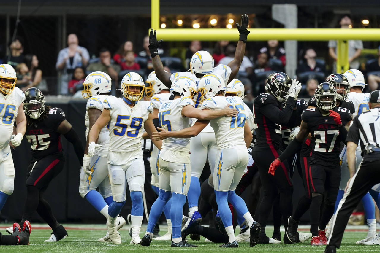 Los Angeles Chargers place kicker Cameron Dicker (15) celebrates with teammate JK Scott after kicki...