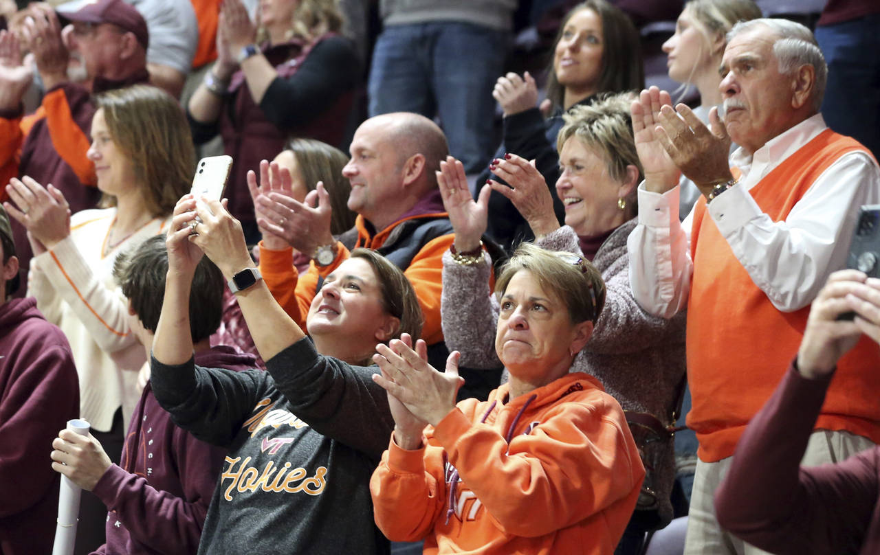 Virginia Tech fans applaud during an unveiling of an ACC championship banner in Cassell Coliseum pr...