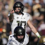 
              Oregon quarterback Bo Nix directs players at the line of scrimmage against Colorado in the first half of an NCAA college football game, Saturday, Nov. 5, 2022, in Boulder, Colo. (AP Photo/David Zalubowski)
            