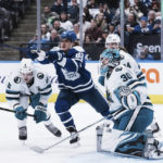 
              Toronto Maple Leafs' William Nylander, center, reaches for the puck in front of San Jose Sharks' Matt Benning, left, and goaltender Aaron Dell during the second period of an NHL hockey game Wednesday, Nov. 30, 2022, in Toronto. (Chris Young/The Canadian Press via AP)
            
