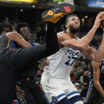 
              Minnesota Timberwolves center Rudy Gobert, center, shoots around Indiana Pacers center Myles Turner, left, during the first half of an NBA basketball game in Indianapolis, Wednesday, Nov. 23, 2022. (AP Photo/AJ Mast)
            