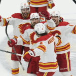 
              Calgary Flames defenseman Rasmus Andersson (4) is congratulated by his teammates after scoring the game winning goal in a shootout at an NHL hockey game against the Florida Panthers, Saturday, Nov. 19, 2022, in Sunrise, Fla. The Flames defeated the Panthers 5-4. (AP Photo/Marta Lavandier)
            