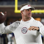 
              Mississippi coach Lane Kiffin passes the ball to a player during warmups for the team's NCAA college football game against Mississippi State in Oxford, Miss., Thursday, Nov. 24, 2022. (AP Photo/Rogelio V. Solis)
            