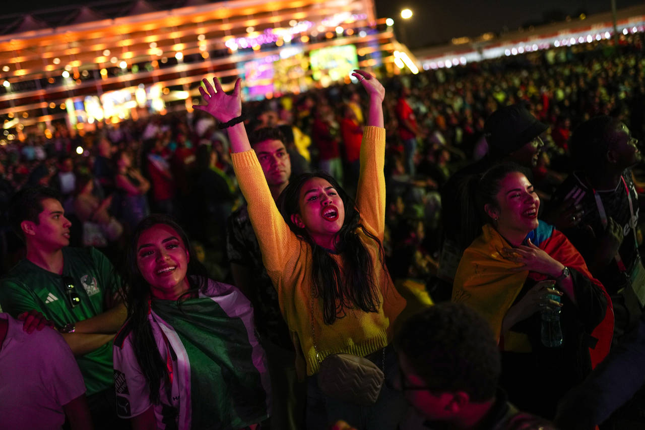 Ecuador fans celebrate their team's second goal as they watch in a giant screen at the fan zone the...