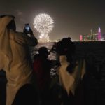 
              Fans watch a drone display and fireworks are seen over the skyline ahead of the FIFA World Cup in Doha, Qatar, Saturday, Nov. 19, 2022. The drone display reads in Arabic: "Welcome to Qatar." (AP Photo/Jon Gambrell)
            