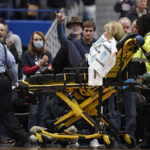 
              Associate Head Coach Chris Dailey is taken off the basketball court on a stretcher before an NCAA basketball game against North Carolina State, Sunday, Nov. 20, 2022, in Hartford, Conn. Dailey experienced a medical emergency during the national anthem. (AP Photo/Jessica Hill)
            