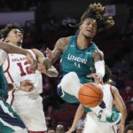 
              UNC Wilmington guard Jamarii Thomas (0) loses control of the ball after a foul by Oklahoma guard Milos Uzan (12) in the first half of an NCAA college basketball game Tuesday, Nov. 15, 2022, in Norman, Okla. (AP Photo/Sue Ogrocki)
            