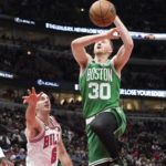 
              Boston Celtics' Sam Hauser drives to the basket past Chicago Bulls' Alex Caruso during the first half of an NBA basketball game Monday, Nov. 21, 2022, in Chicago. (AP Photo/Charles Rex Arbogast)
            