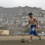 
              An Afghan youth plays soccer on a makeshift pitch in an open field, on the outskirts of Kabul, Afghanistan, Sunday, Nov. 13, 2022. (AP Photo/Ebrahim Noroozi)
            