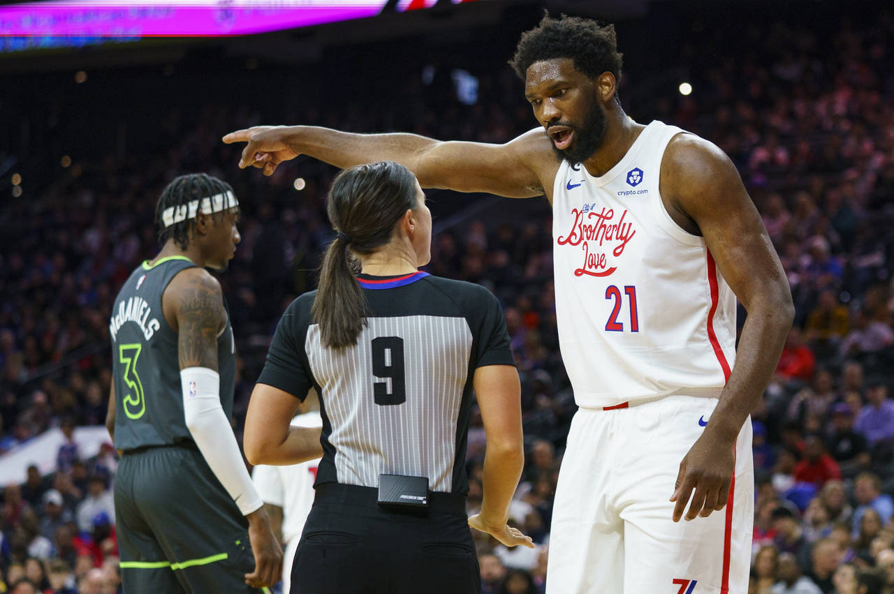 Philadelphia 76ers' Joel Embiid, right, reacts to a call by official Natalie Sago, center, during t...
