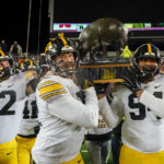 
              Iowa defensive linemen Yahya Black, right, and John Waggoner, center, carry the Floyd of Rosedale trophy back to their locker room after defeating Minnesota in an NCAA college football game on Saturday, Nov. 19, 2022, in Minneapolis. (AP Photo/Craig Lassig)
            