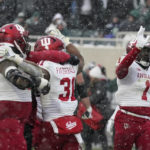 
              Indiana team members hug Indiana defensive back Bryant Fitzgerald (31) after the second overtime of an NCAA college football game against Michigan State, Saturday, Nov. 19, 2022, in East Lansing, Mich. (AP Photo/Carlos Osorio)
            