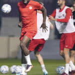 
              Canada star Alphonso Davies, left, grimaces during a warmup drill at the World Cup in Doha, Qatar, on Monday, Nov. 21, 2022. Davies, who is coming back from a hamstring strain, returned to the warmup. (Nathan Denette/The Canadian Press via AP)
            