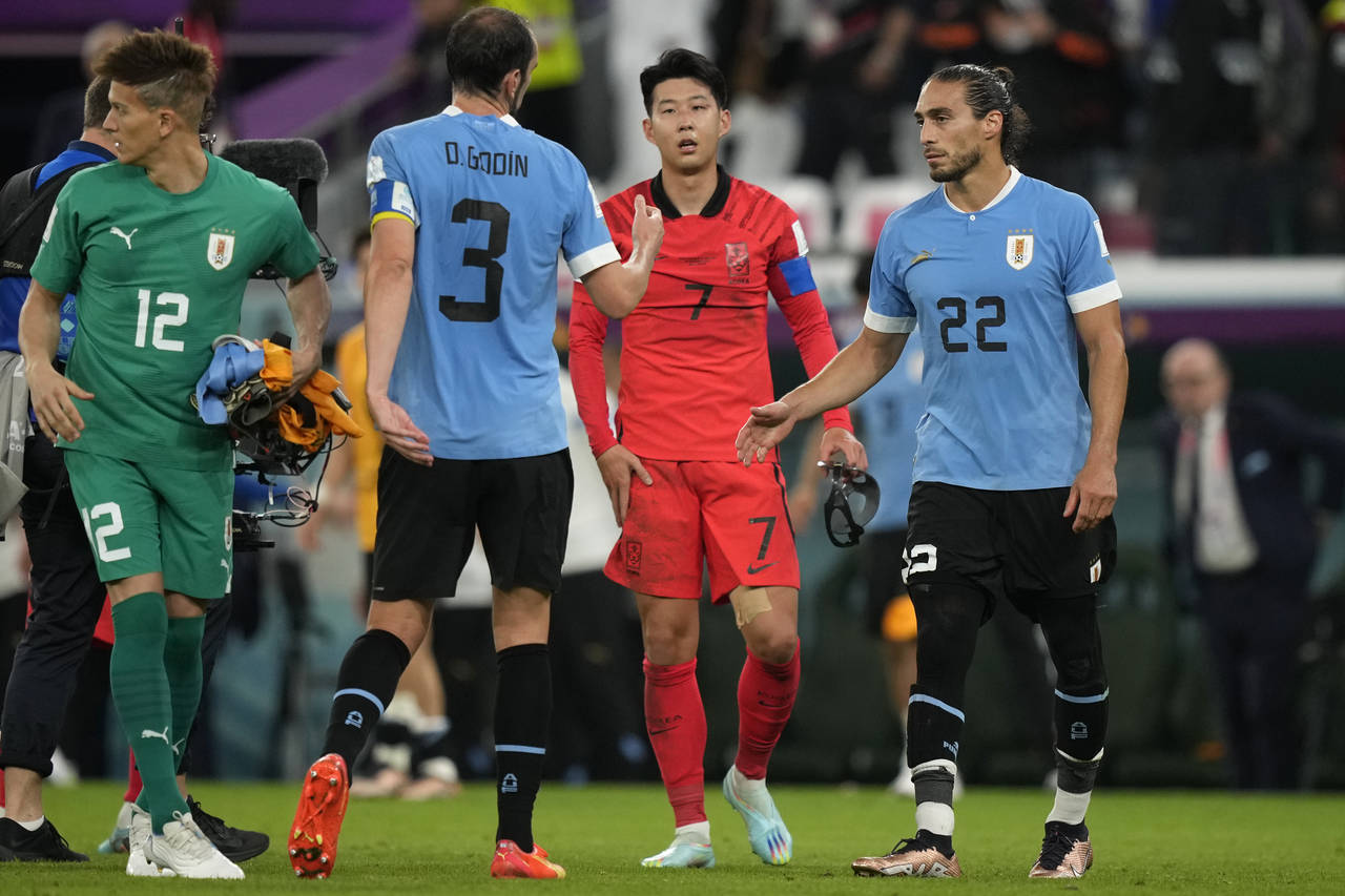 South Korea's Son Heung-min, second right, walks to greet Uruguay players at the end of the World C...