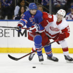 
              New York Rangers right wing Julien Gauthier, left, and Detroit Red Wings defenseman Gustav Lindstrom battle for the puck during the first period of an NHL hockey game Sunday, Nov. 6, 2022, in New York. (AP Photo/John Munson)
            